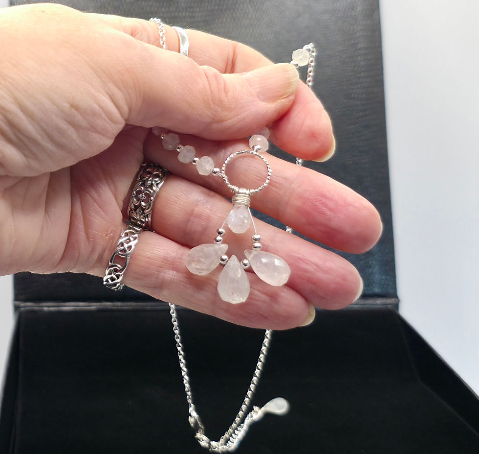 Thumbnail: Hand holding sterling silver and rainbow moonstone necklace