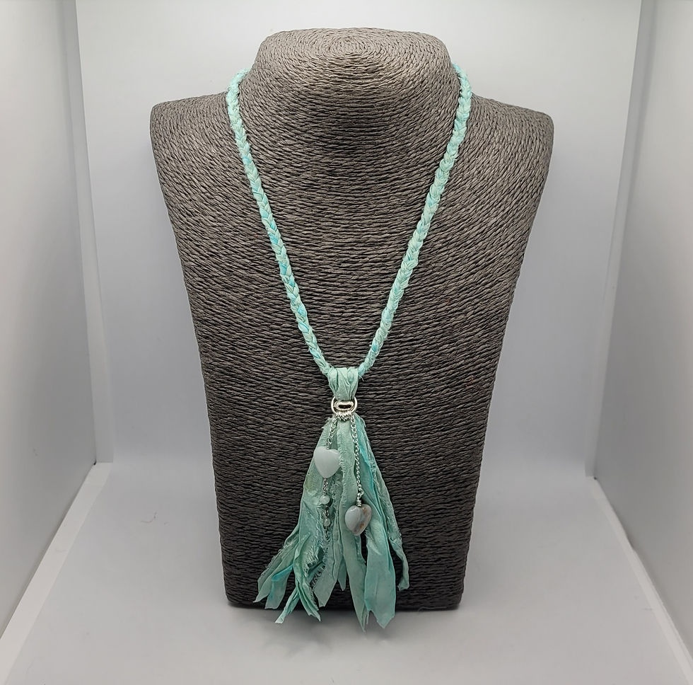 Thumbnail: Pale green plaited sari silk longline with matching tassel at the bottom, decorated with amazonite heart beads and silver plaited chain. Displayed on grey necklace bust.