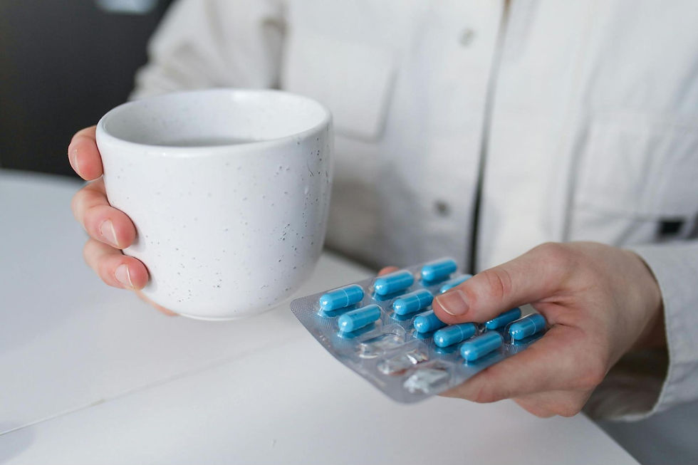 person holding cup and medications