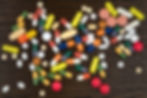 assorted pills on wooden surface