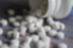 white tablets spilling out of a container