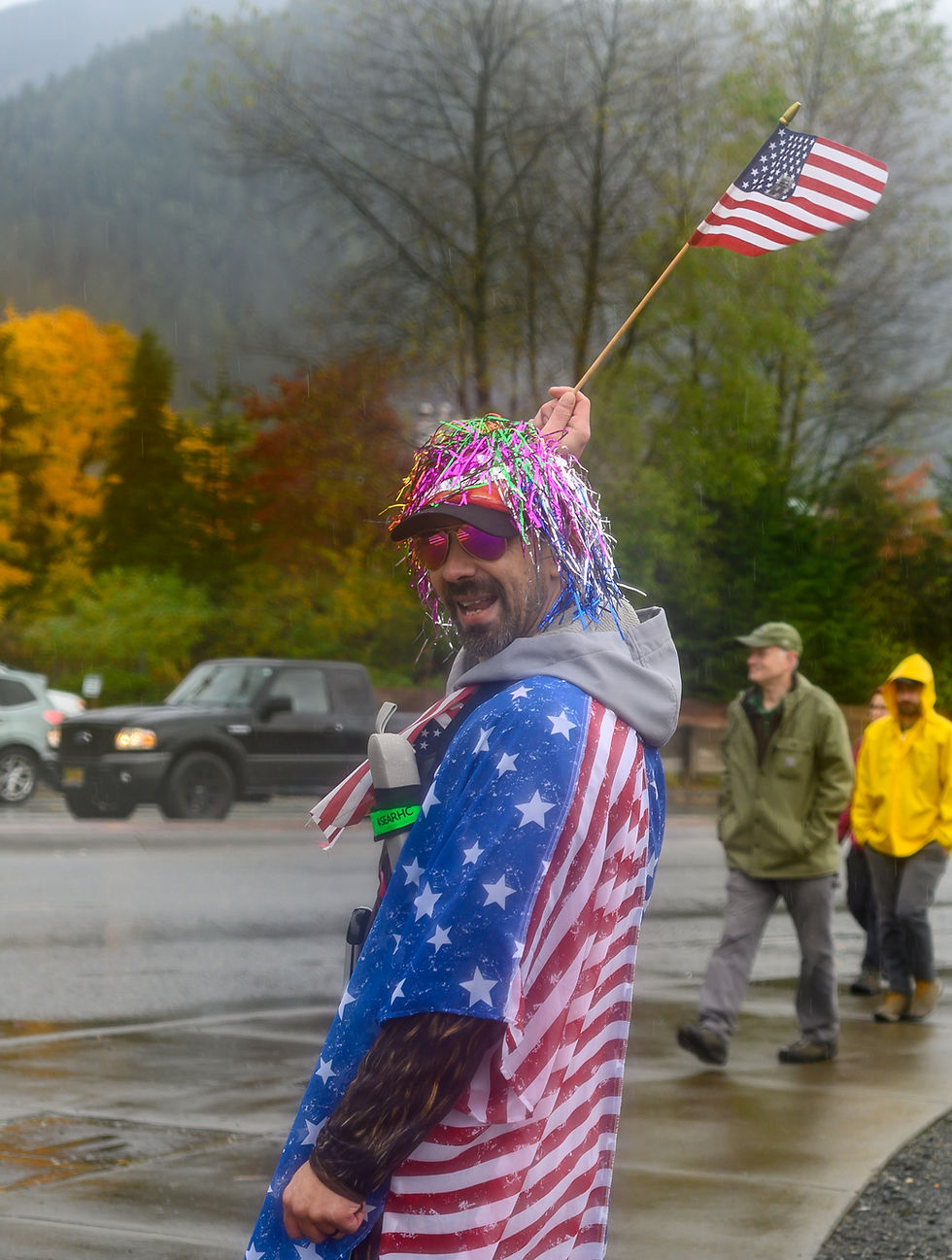 Raven Waid sings in protest near Egan Drive while people leave on Saturday, Oct. 18, 2025. (Jasz Garrett / Juneau Independent)