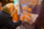 David Brown signs the banner “Release the Miners” at Chapel by the Lake during a Juneau Flood Solution Advocates meeting on Thursday, June 25, 2026. (Jasz Garrett / Juneau Independent)