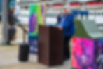 Mayor Beth Weldon speaks at the winning artist unveiling ceremony of "Keep Bears Wild" downtown on Tuesday, July 14, 2026. To the left is the art design memorializing the electrocuted cubs. (Jasz Garrett / Juneau Independent)