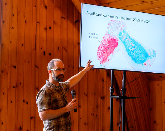 Jason Amundson, University of Alaska Southeast geophysics professor, points to a slide showing significant ice dam thinning of the Mendenhall Glacier from 2025 to 2026 on Thursday, June 25, 2026. (Jasz Garrett / Juneau Independent)