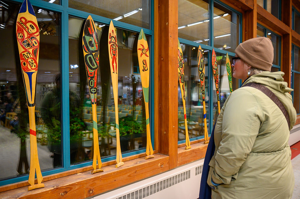 After the event, Brooke Rohweder Kenney looks at paddles carved by University of Alaska Southeast students of Wayne Price on Monday, Oct. 12, 2026. (Jasz Garrett / Juneau Independent)