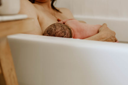mother giving birth in a tub