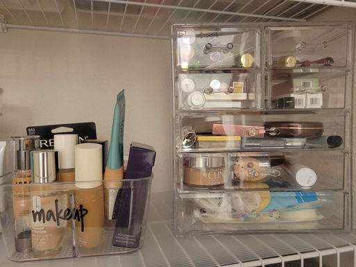 Organized cosmetics stored in labeled acrylic bins with makeup products categorized for easy access and visibility.
