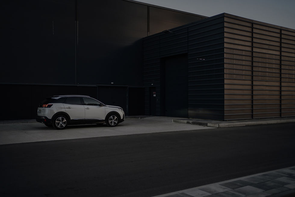 white coupe parked beside gray building_edited.jpg