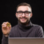 portrait-happy-entrepreneur-showing-bitcoin-while-sitting-desk-with-laptop-computer-isolat