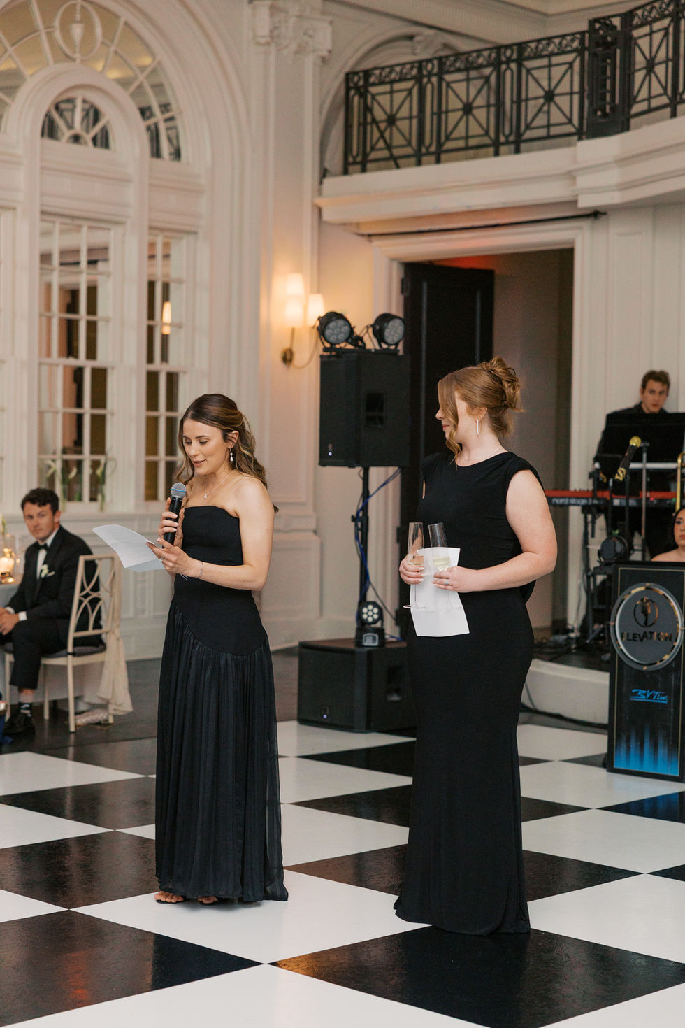 Two women speaking at a formal event.