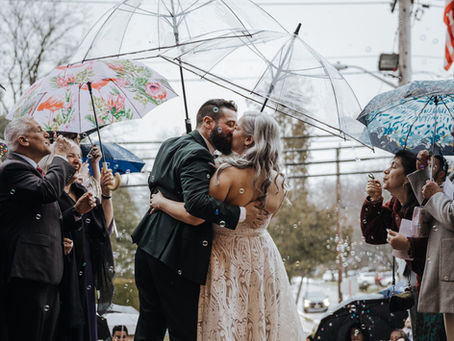 Bride and Groom Kissing in the rain after wedding ceremony.  