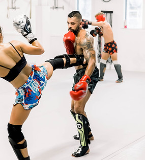 Muay thai tudent spars her kickboxing coach at their Goleta gym