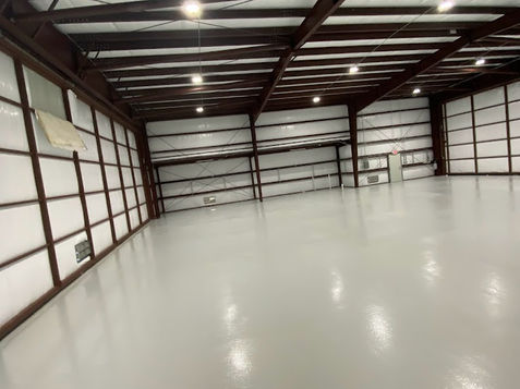 High-quality polished concrete floor with a smooth, glossy finish and epoxy resinous flooring, showcasing a modern, durable surface ideal for residential and commercial spaces
