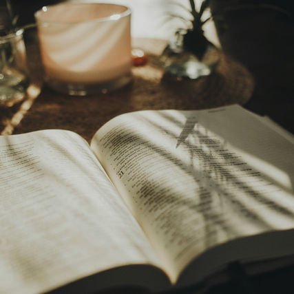 Flat lay of an open Bible with a candle for devotional time.