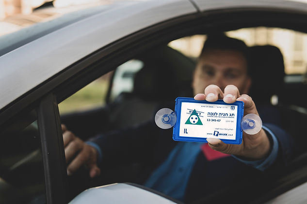 איש ברכב מציג תג נכה לרכב.jpg