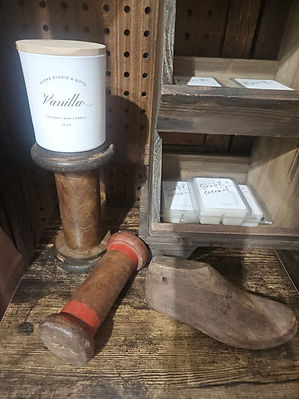 Merchandise Display Shelf inside Evoke Studio & Gifts featuring candles, antique candlesticks, and wax melts