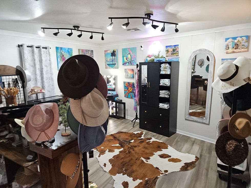 Interior of Evoke Studio & Gifts showing a display of hats, wall art, shelves of textiles, and boutique fixtures.