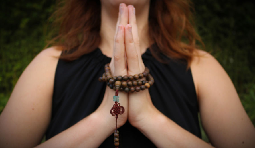 Dani Frank, therapeutic yoga teacher, demonstrating a healing Mudra for mindfulness and balance in a Sole Journey Wellness session.