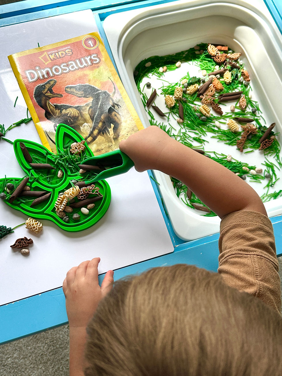 Eye-level view of a toddler exploring colorful textured balls in a sensory bin