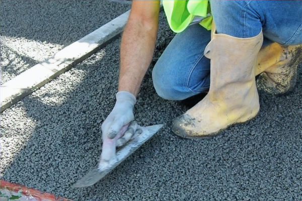 Ouvrier installant du béton drainant par l'entreprise bâtiment