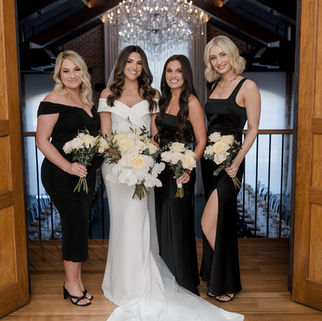 Bride and bridesmaids in black dresses with ivory floral bouquets – Gold Coast wedding florist Nativa Floral.