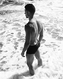 man standing in the waves, an advert for dermal therapy