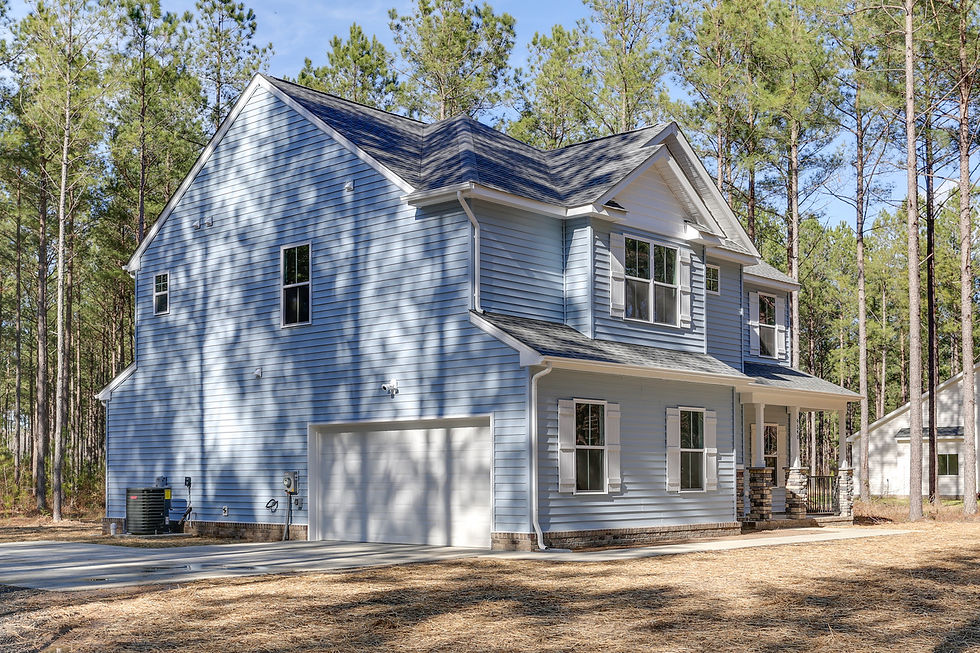 Two-story light blue house with white garage and shutters