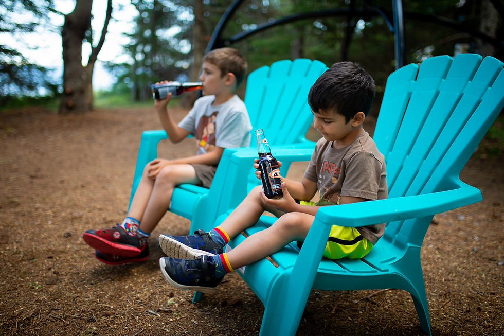 Kids sitting at a camp site and enjoying a beverage