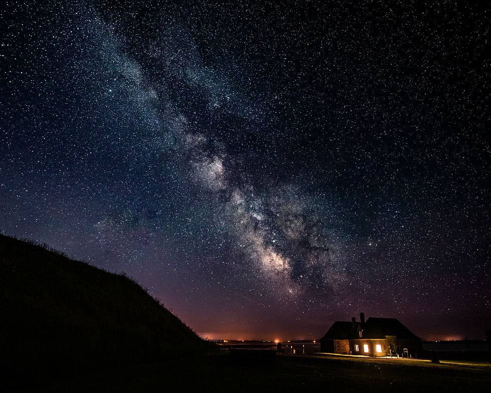 Night time shot of a historic building with the milkyway on top of it