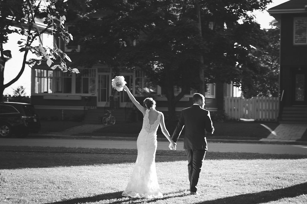 Bride and groom are walking away, bride has her bouquet up in the air