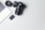 Photographer's workplace on a white background. Modern laptop, digital camera, lens, batte