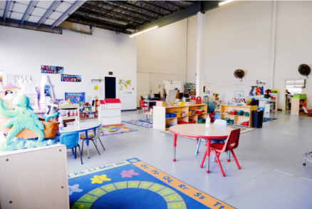 Bright, open classroom with tables, chairs, and learning materials About a daycare.