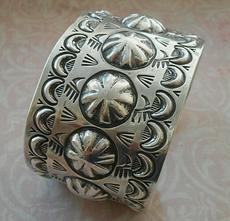 Close-up view of a silver cuff bracelet with intricate designs