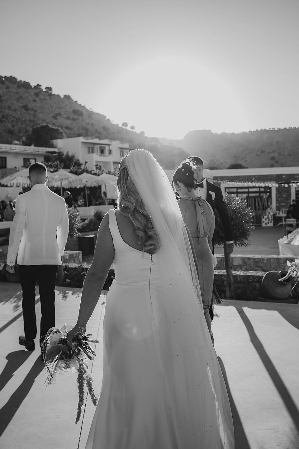 bride walking with veil blowing in the wind