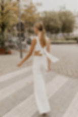 Back view of Two-piece top and pant wedding outfit on bride