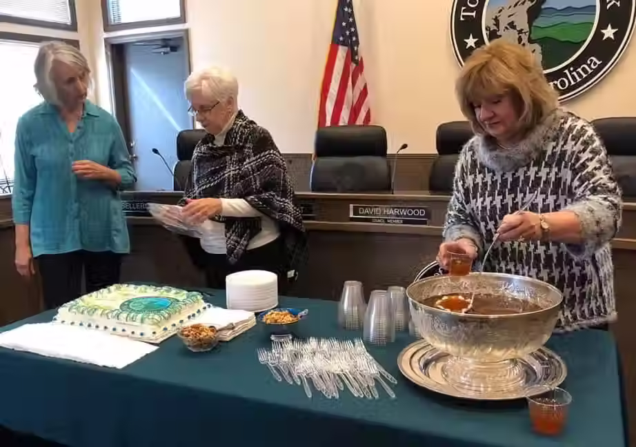 Three elegant women serving food for the guests.