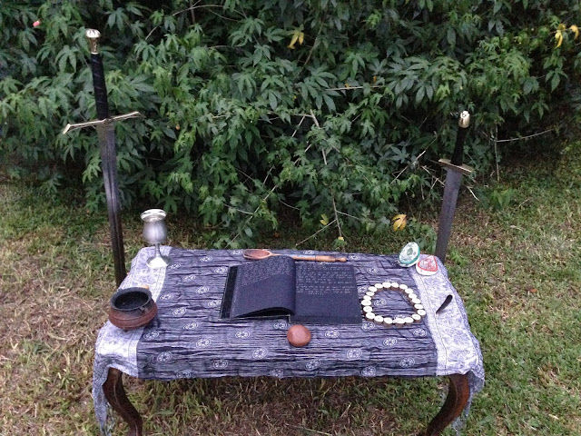 Gorsedd (espécie de altar) de Mirian Black. Em cada canto há os instrumentos encantados de Draíocht - Magia Druídica ou Magia Avançada, juntamente com o Oráculo Ogham, o livro encantado escrito com o alfabeto Tengwar (dos elfos, criado por Tolkien) e espadas fincadas ao chão, uma de Mirian e outra de seu marido.