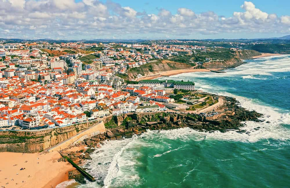 Aerial view of Ericeira, Portugal, with beaches, cliffs, and ocean waves.