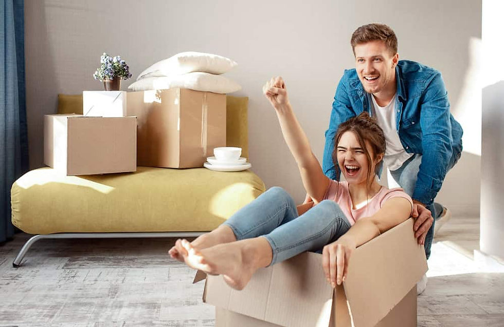 Happy couple moving into a new home with their First Night Box, as well as other boxes.