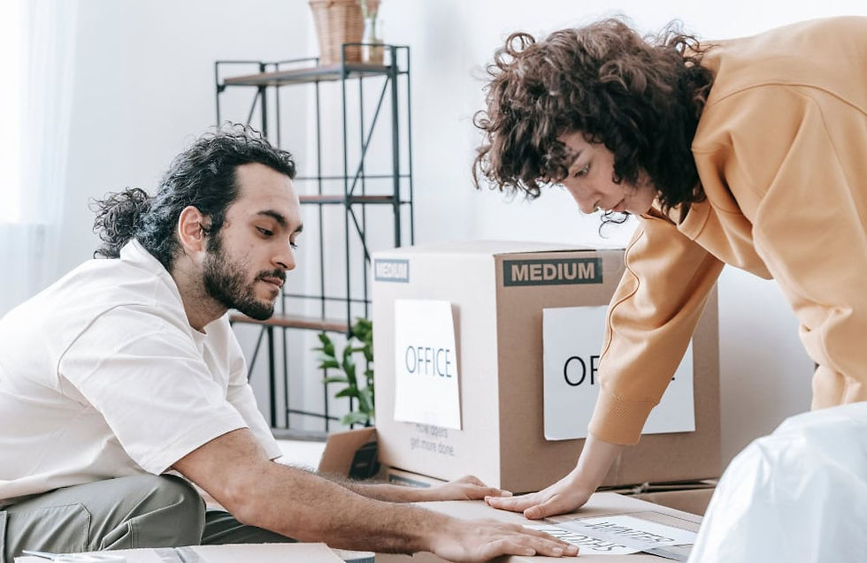 Couple labelling moving boxes clearly to stay organised during a house move.