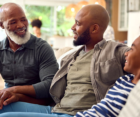 Laughing Multi-Generation Male Family Hanging Out on Sofa at Home Talking Together.jpg