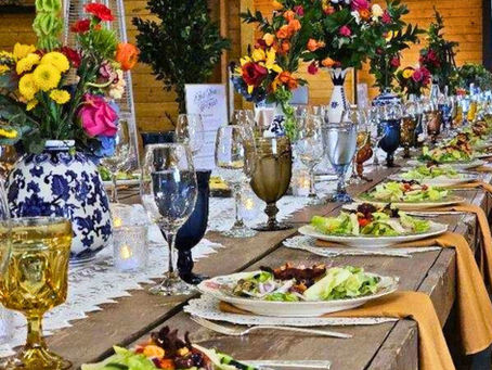 Masterpiece Cuisine long event table styled with fresh salads and vibrant floral decor.