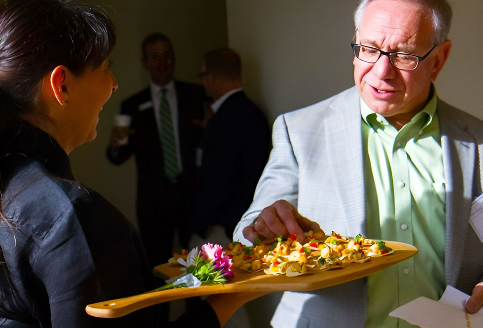 An attendee enjoying hors d'oeuvres served by Masterpiece Cuisine staff.