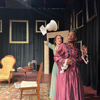 Girl in mint dress holds a vase over her head threateningly, stands over girl in purple dress