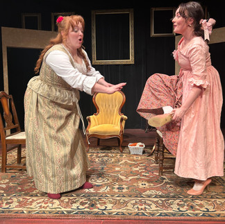 The girl on the right in pink offers her shoe to the girl on the left in green, who is refusing it.