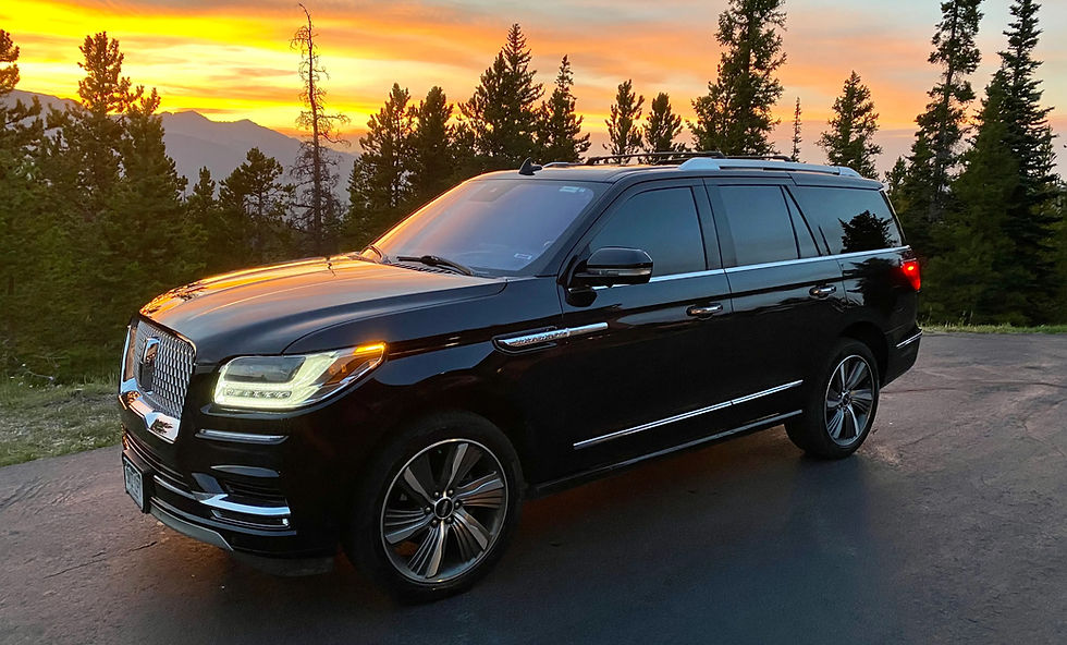 Black Lincoln Navigator luxury SUV parked at sunset in the Colorado mountains, ideal for private transportation to Breckenridge and Vail