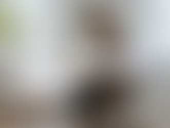 Woman in blazer typing on laptop at a white desk in a bright room. Text overlay: "Top Interview Questions to Hire a Rockstar VA."