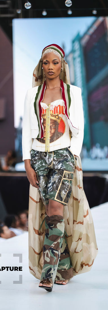 Model walks the runway with colorful outfit; indie fashion show performance.