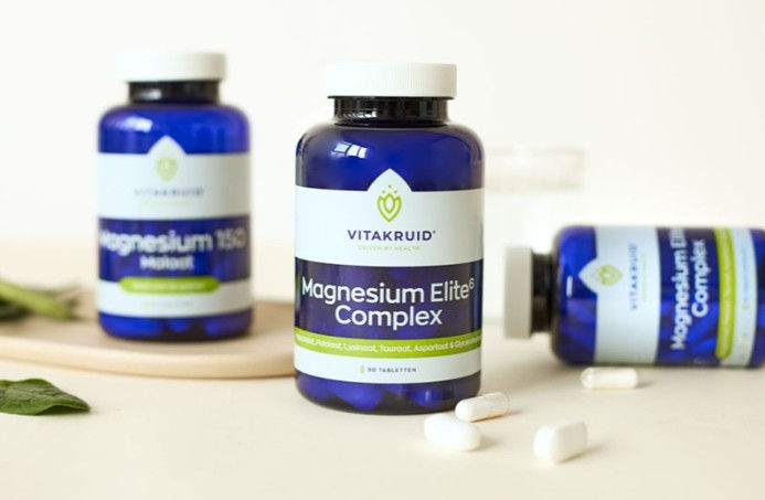 Thumbnail: Drie blauwe potten Vitakruid Magnesium Complex met losse capsules op een lichte ondergrond.